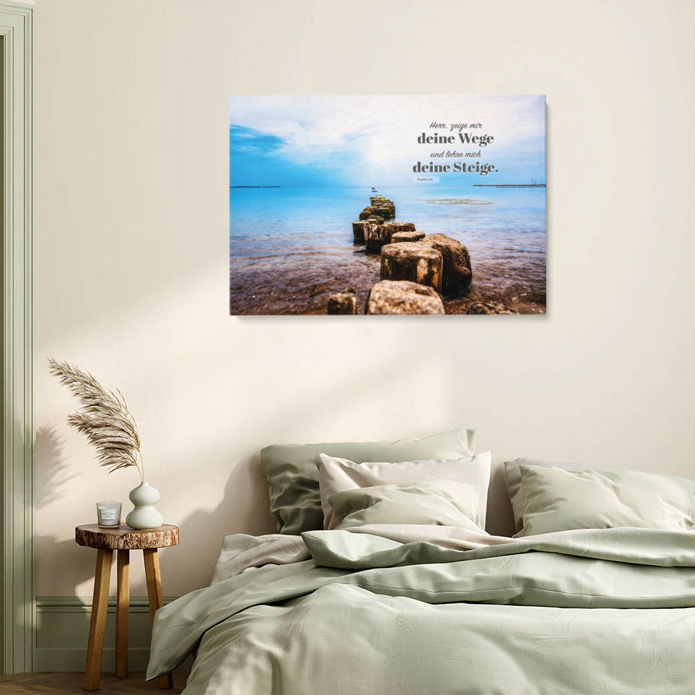Bibelvers-Leinwand „Herr, zeige mir deine Wege“ im hellen Schlafzimmer – Naturfarben, Meer, Holzpfähle als Symbolweg